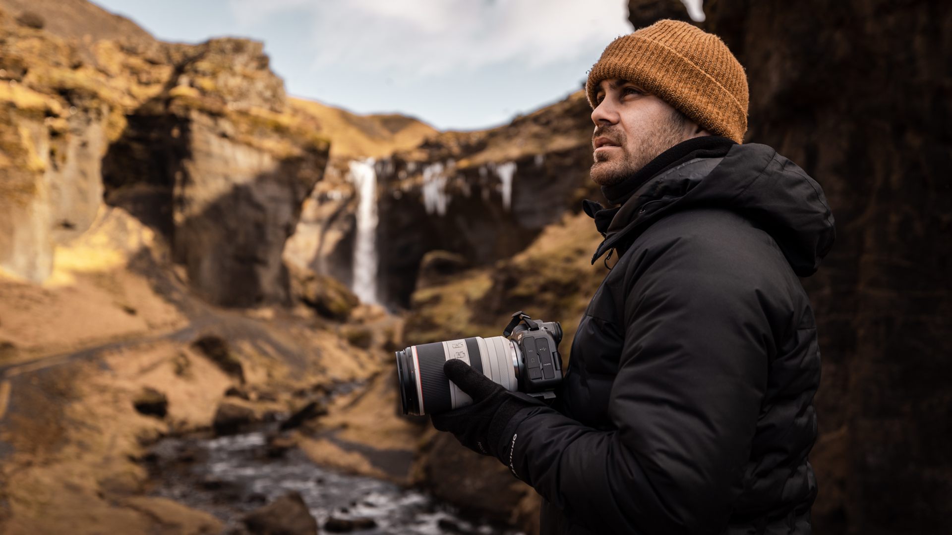 JC Pieri caméra à la main devant une cascade en Islande